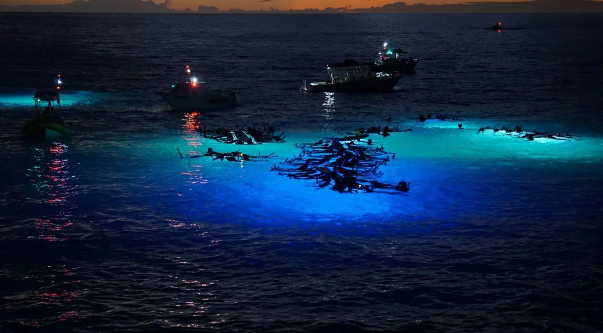 Tour boats and illuminated water at a night snorkeling site
